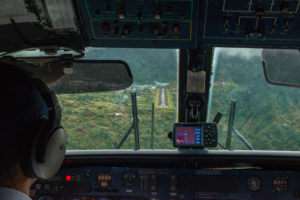 Approaching Lukla airport. Looking at the airport from the cockpit of the small twin engine plane Twin Otter.