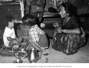 A little girl applying bhai tika to her brother in Mauja, Kaski in 1973 - Old Photos Of Nepal
